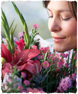 Женщина наслаждается ароматом подаренного букета цветов