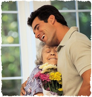 Взрослый сын поздравляет маму с праздником букетом цветов